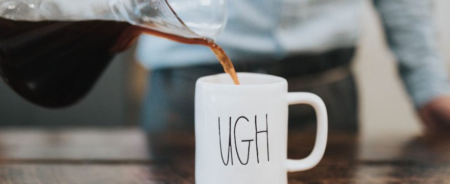Coffe being poured into a mug that says ugh