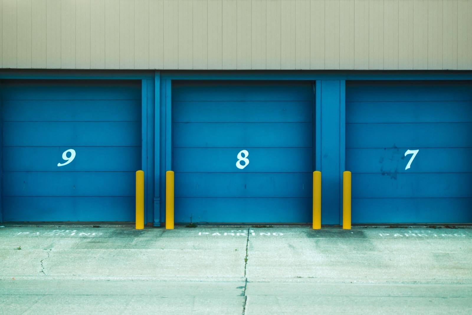 3 blue garage doors numbered 7, 8 and 9