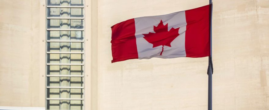 A waving Canadian flag in front of the CN Tower