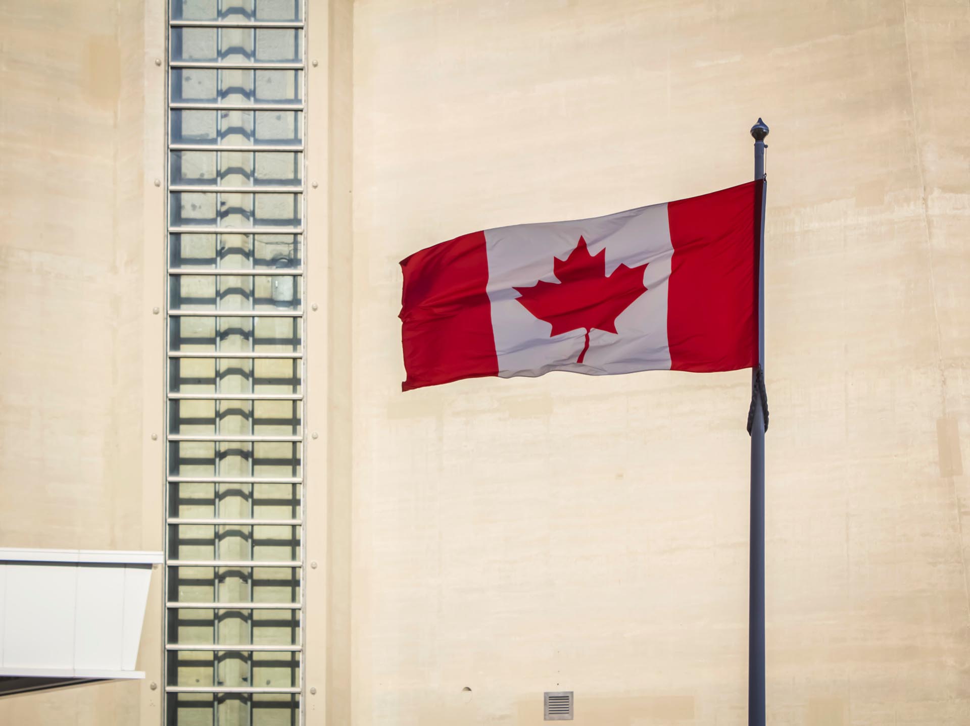 A waving Canadian flag in front of the CN Tower